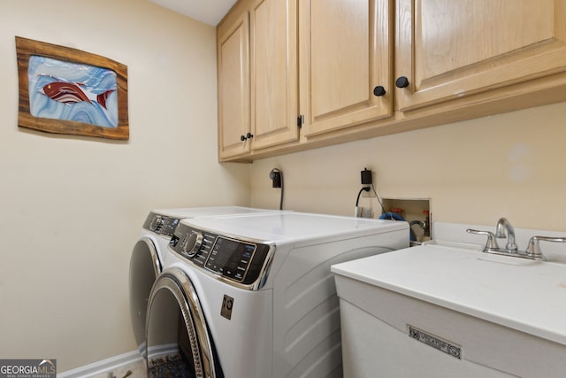 clothes washing area featuring washer and clothes dryer and cabinets