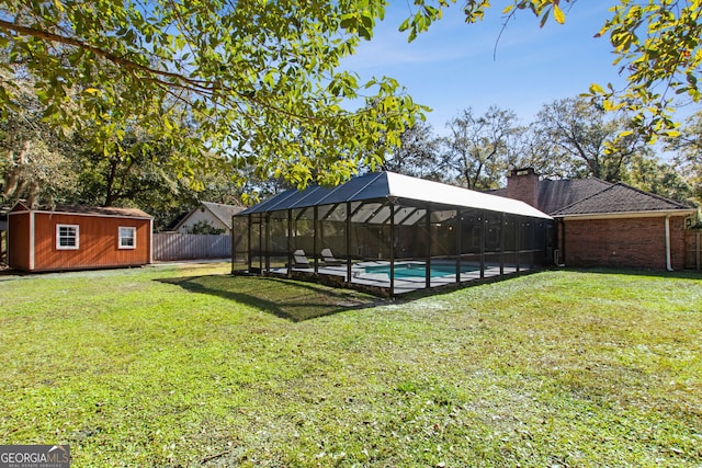 view of yard with a storage shed and glass enclosure