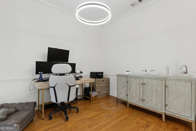 office space with crown molding and light hardwood / wood-style flooring