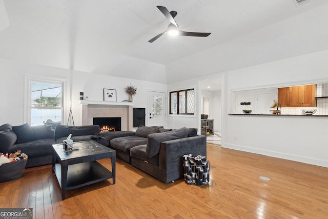 living room with light wood-type flooring, ceiling fan, and lofted ceiling