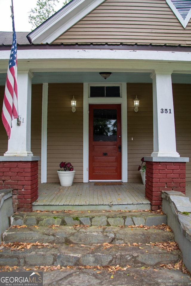 view of exterior entry featuring covered porch