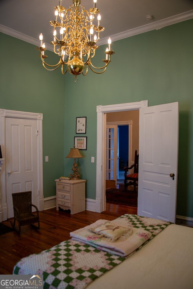 bedroom with dark wood-type flooring, ornamental molding, and a notable chandelier