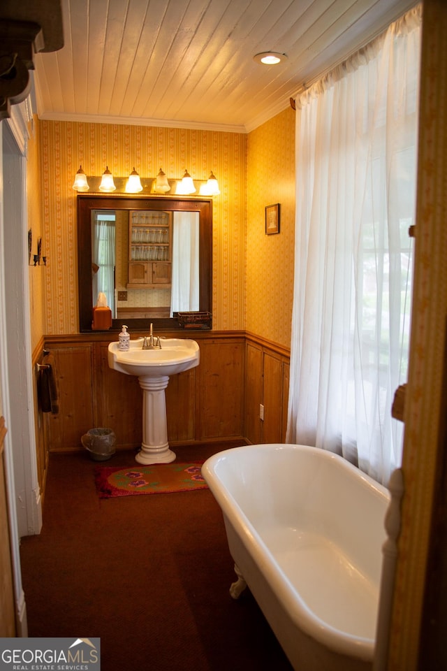 bathroom with a tub, wood ceiling, and crown molding