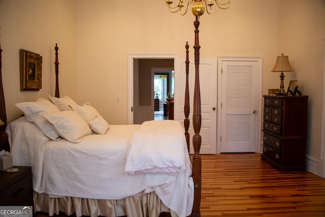 bedroom featuring a closet, a notable chandelier, and hardwood / wood-style flooring