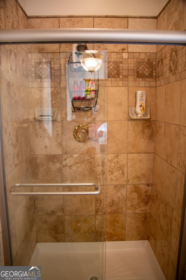 bathroom with a shower with door