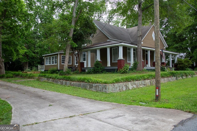 view of front of property with covered porch and a front yard