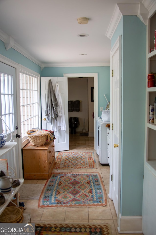 mudroom featuring separate washer and dryer, light tile patterned floors, and ornamental molding