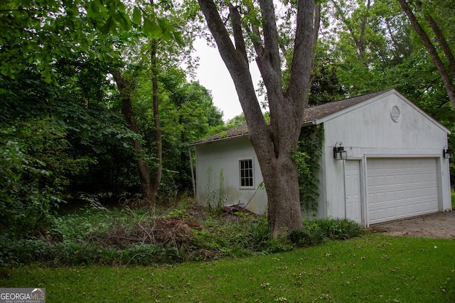 view of property exterior with a garage, an outbuilding, and a yard