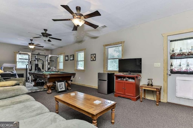 living room featuring a healthy amount of sunlight, pool table, and dark colored carpet