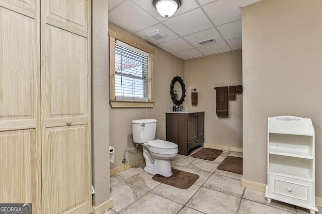 bathroom with toilet, tile patterned flooring, and a drop ceiling