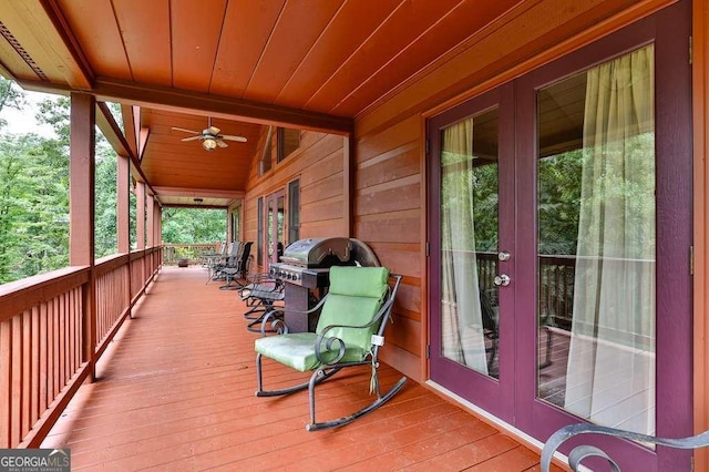 wooden terrace with ceiling fan, a grill, and french doors