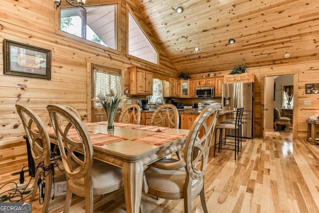 dining space with wooden ceiling, light hardwood / wood-style flooring, wooden walls, and high vaulted ceiling