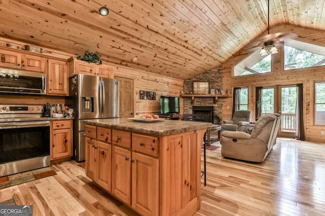 kitchen with light hardwood / wood-style floors, wooden ceiling, appliances with stainless steel finishes, a fireplace, and a kitchen island