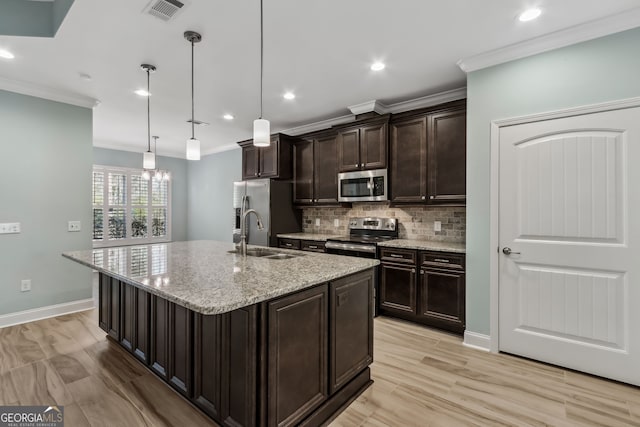 kitchen with dark brown cabinetry, a sink, appliances with stainless steel finishes, visible vents, and decorative backsplash