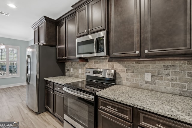 kitchen featuring decorative backsplash, visible vents, dark brown cabinets, appliances with stainless steel finishes, and a sink