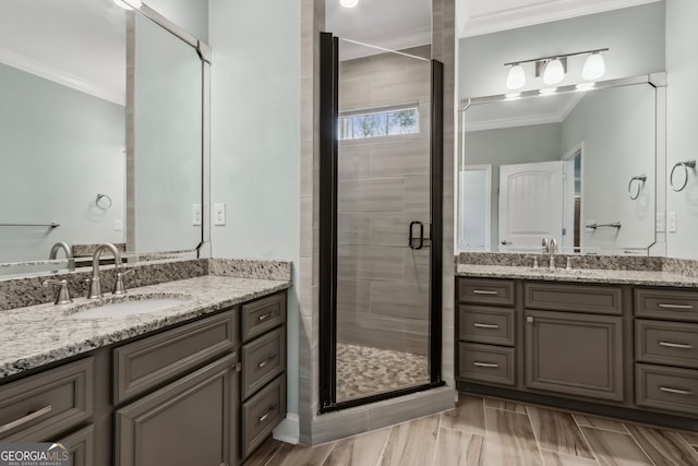 bathroom with crown molding, vanity, a shower stall, baseboards, and wood tiled floor