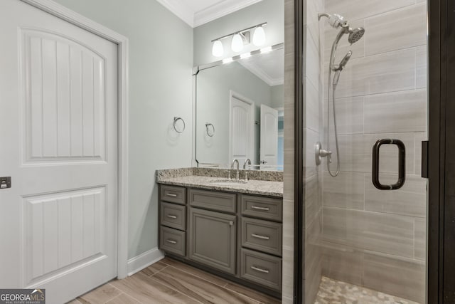bathroom featuring a sink, a stall shower, and crown molding