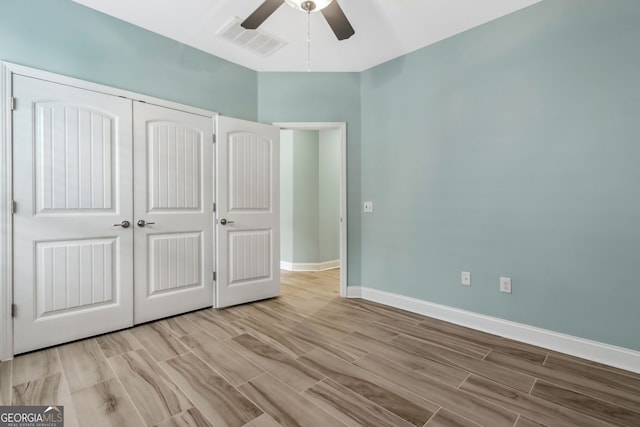 spare room with light wood-style flooring, baseboards, ceiling fan, and visible vents