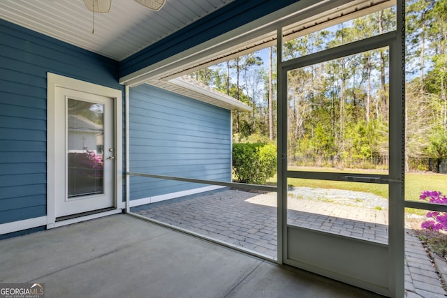 unfurnished sunroom with a ceiling fan