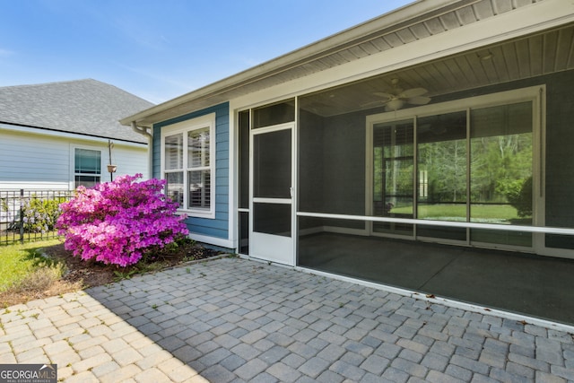unfurnished sunroom featuring ceiling fan