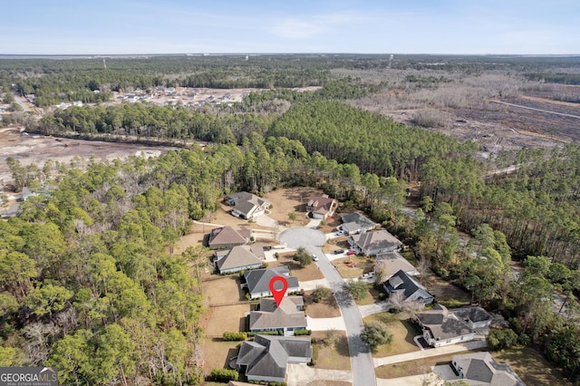 drone / aerial view featuring a residential view and a wooded view