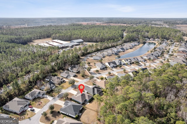 drone / aerial view with a residential view, a water view, and a view of trees