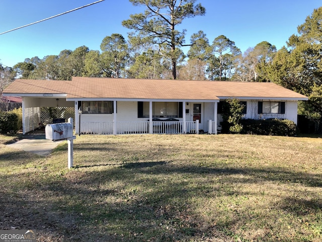 ranch-style house with a front lawn, a carport, and covered porch