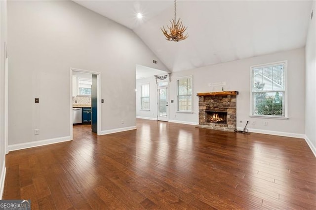 unfurnished living room featuring dark wood-type flooring, a fireplace, and high vaulted ceiling