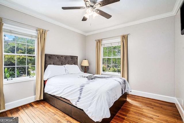 bedroom with ceiling fan, wood-type flooring, and crown molding