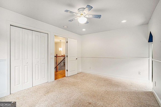 unfurnished bedroom with ceiling fan, carpet flooring, and a closet