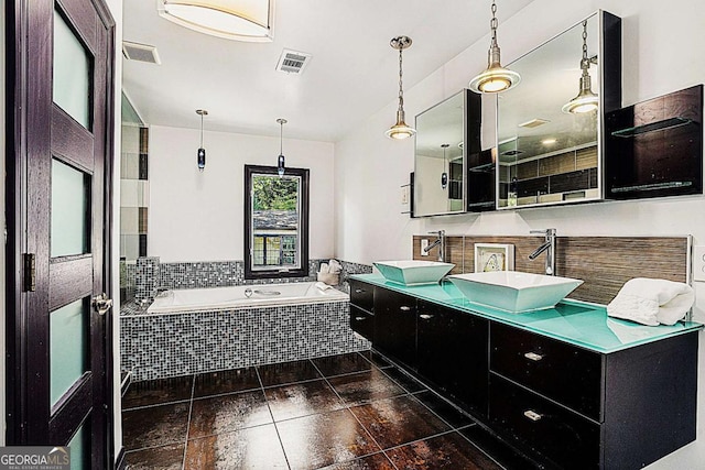 bathroom featuring tiled tub and vanity