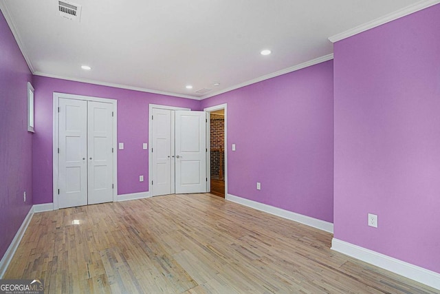 unfurnished bedroom featuring light wood-type flooring and ornamental molding