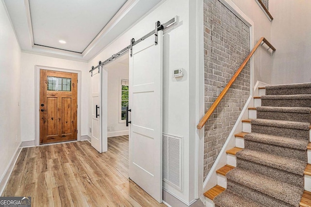 foyer with light wood-type flooring and a barn door