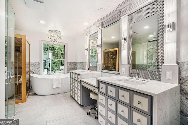 bathroom featuring tile patterned floors, vanity, tile walls, a notable chandelier, and separate shower and tub