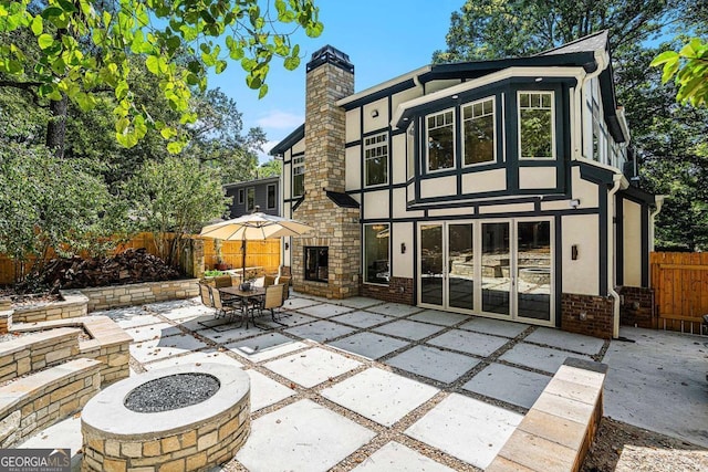 rear view of house with a patio area and a fire pit