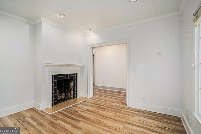 unfurnished living room featuring a fireplace, crown molding, and light hardwood / wood-style floors