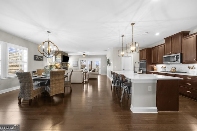 dining area with an inviting chandelier, recessed lighting, dark wood-style floors, and baseboards