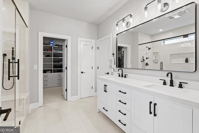 bathroom featuring a shower stall, a spacious closet, visible vents, and a sink