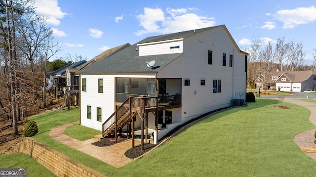 back of property with a yard, a wooden deck, stairs, and central AC