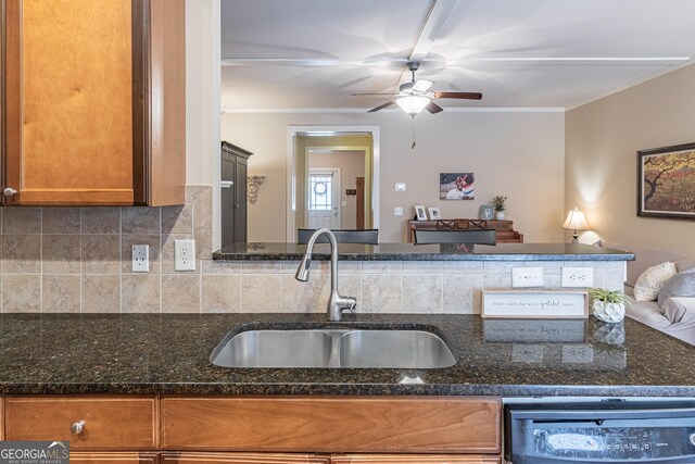 kitchen featuring sink, tasteful backsplash, dark stone countertops, ornamental molding, and dishwashing machine