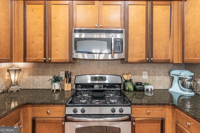 kitchen featuring dark stone countertops, backsplash, and appliances with stainless steel finishes