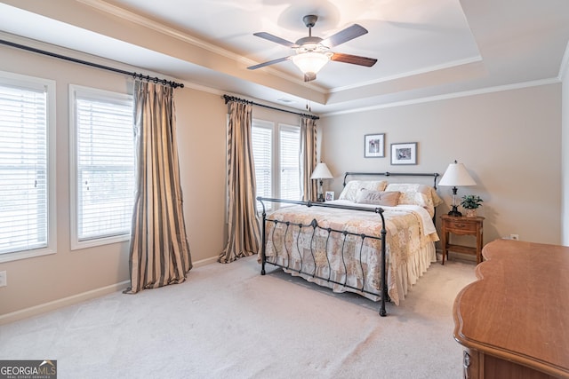 carpeted bedroom with ceiling fan, ornamental molding, and a raised ceiling