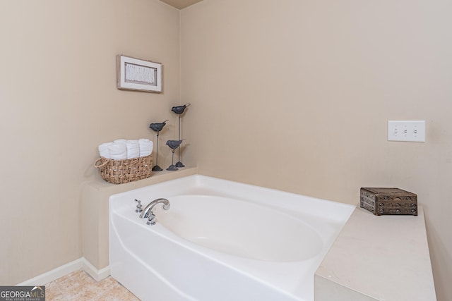 bathroom with a washtub and tile patterned floors