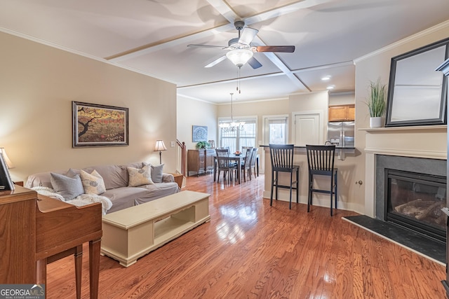 living room featuring crown molding, ceiling fan, coffered ceiling, and light hardwood / wood-style flooring