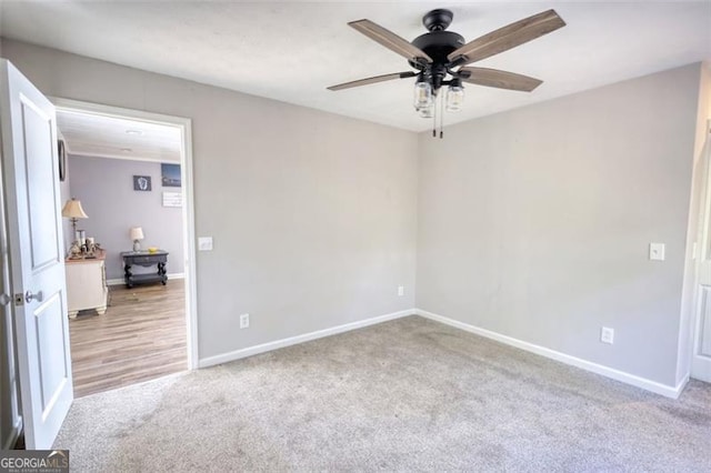 empty room featuring ceiling fan and light colored carpet