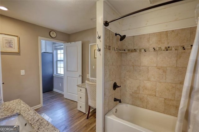 bathroom featuring hardwood / wood-style flooring, vanity, and shower / tub combo with curtain