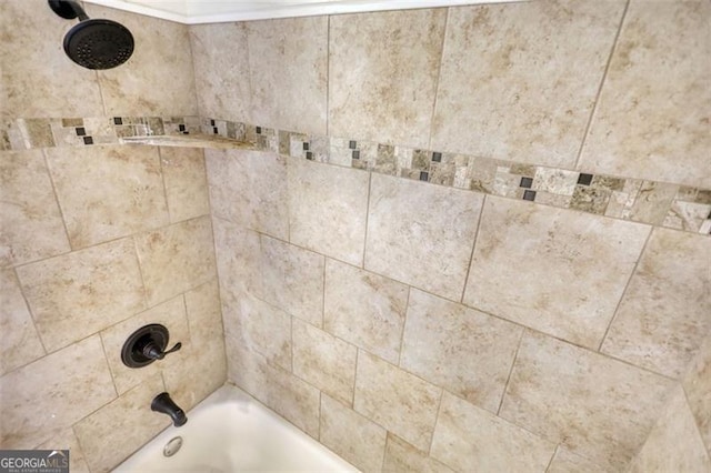 interior details featuring tiled shower / bath combo