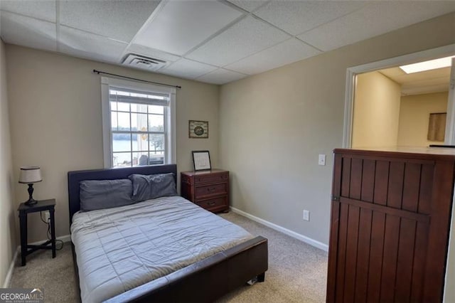 carpeted bedroom with a drop ceiling