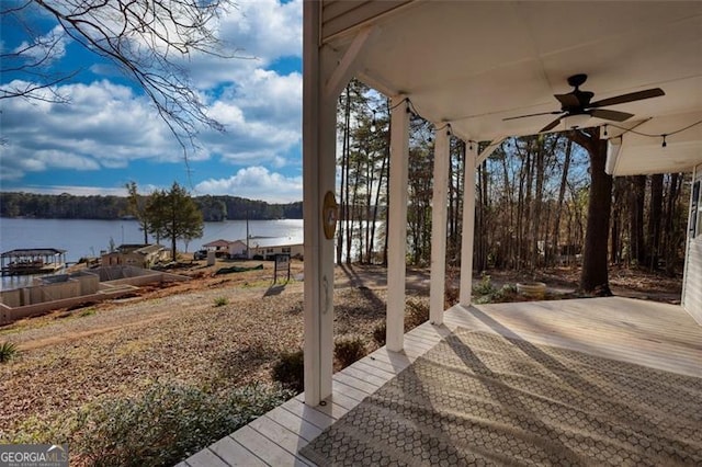 wooden deck with ceiling fan and a water view