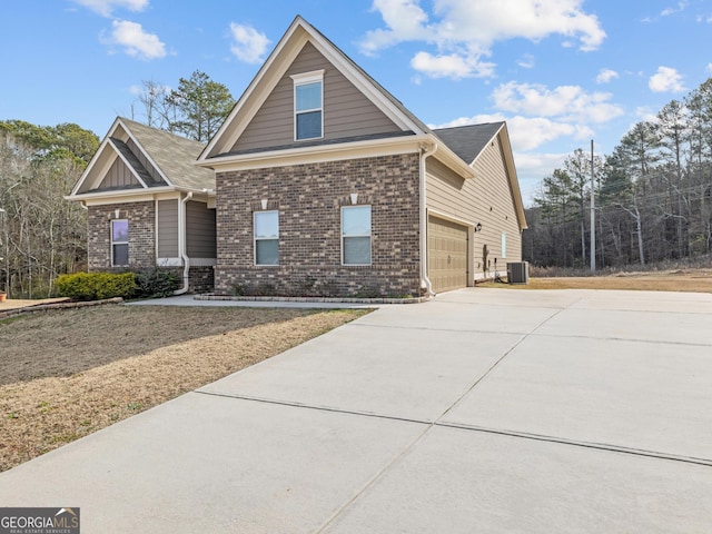 view of front facade featuring a garage, driveway, brick siding, and central AC unit